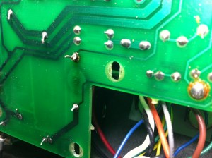 Viewing the same area as the previous pic but from the bottom side of the board you can see the trace that connects to the power supply dropping resistor has broken off the PCB. Between the two traces you can see the charring of the board on the other side. In cases like this where the PCB has been damaged the component must be hardwired.